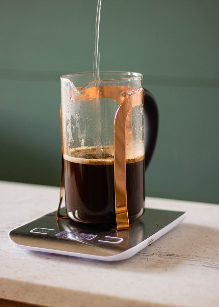 Adding more water to the corase coffee in a French Press