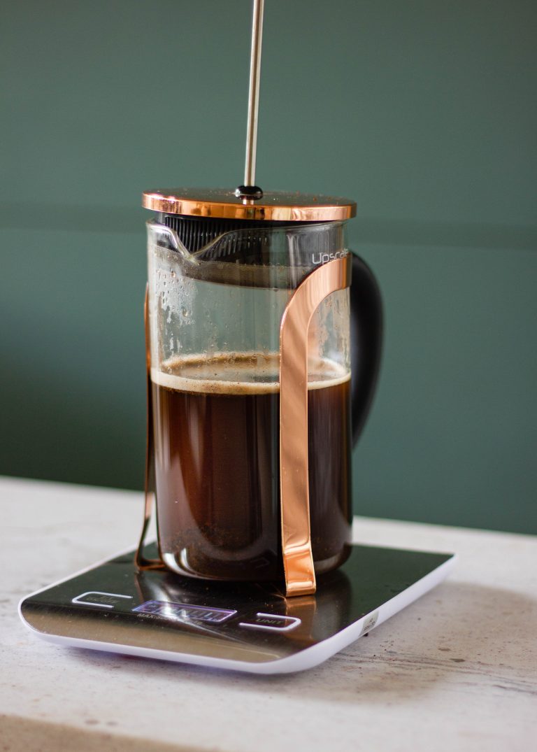coffee brewing in a French Press with the lid on